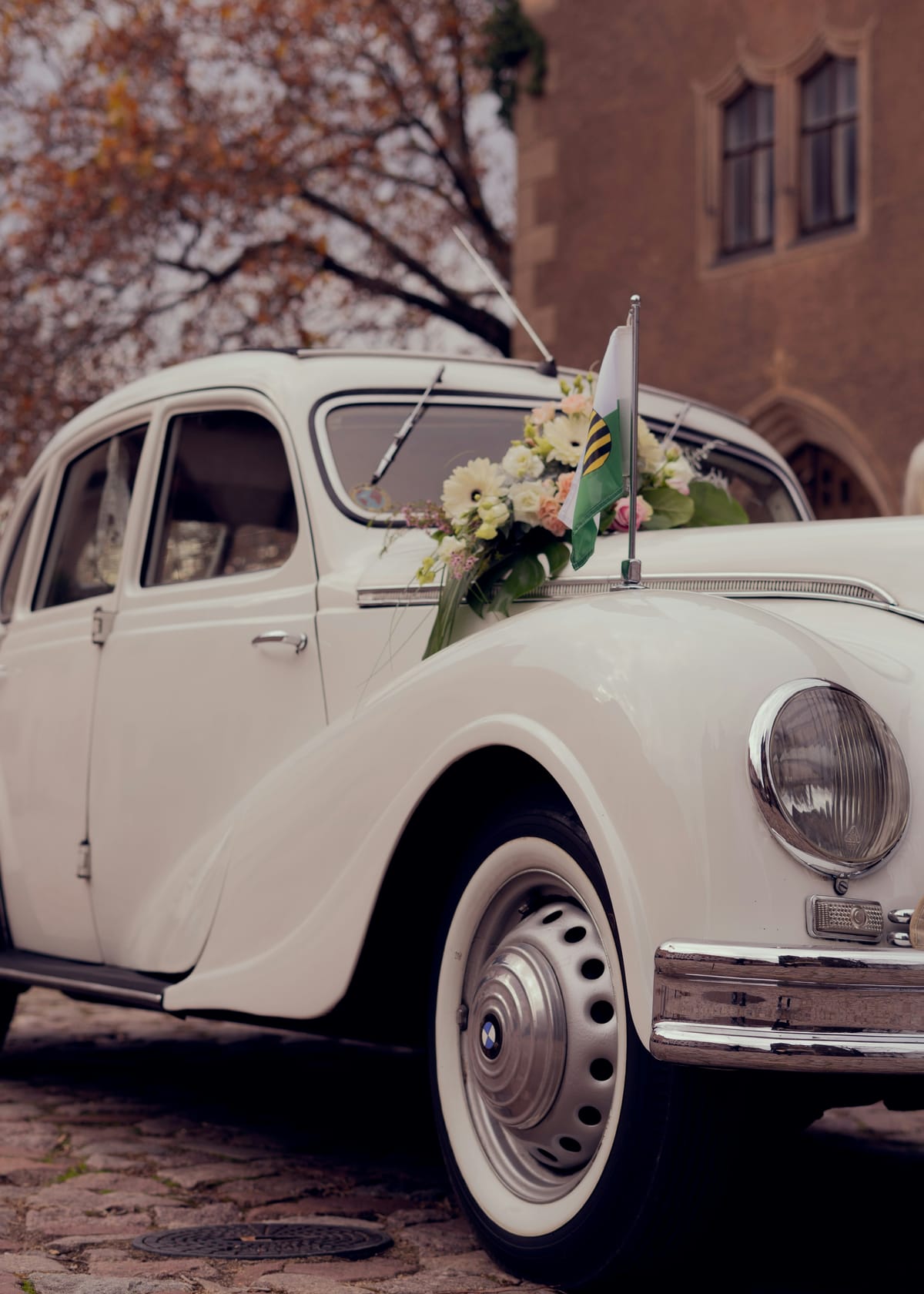 A vintage wedding car dressed with flowers