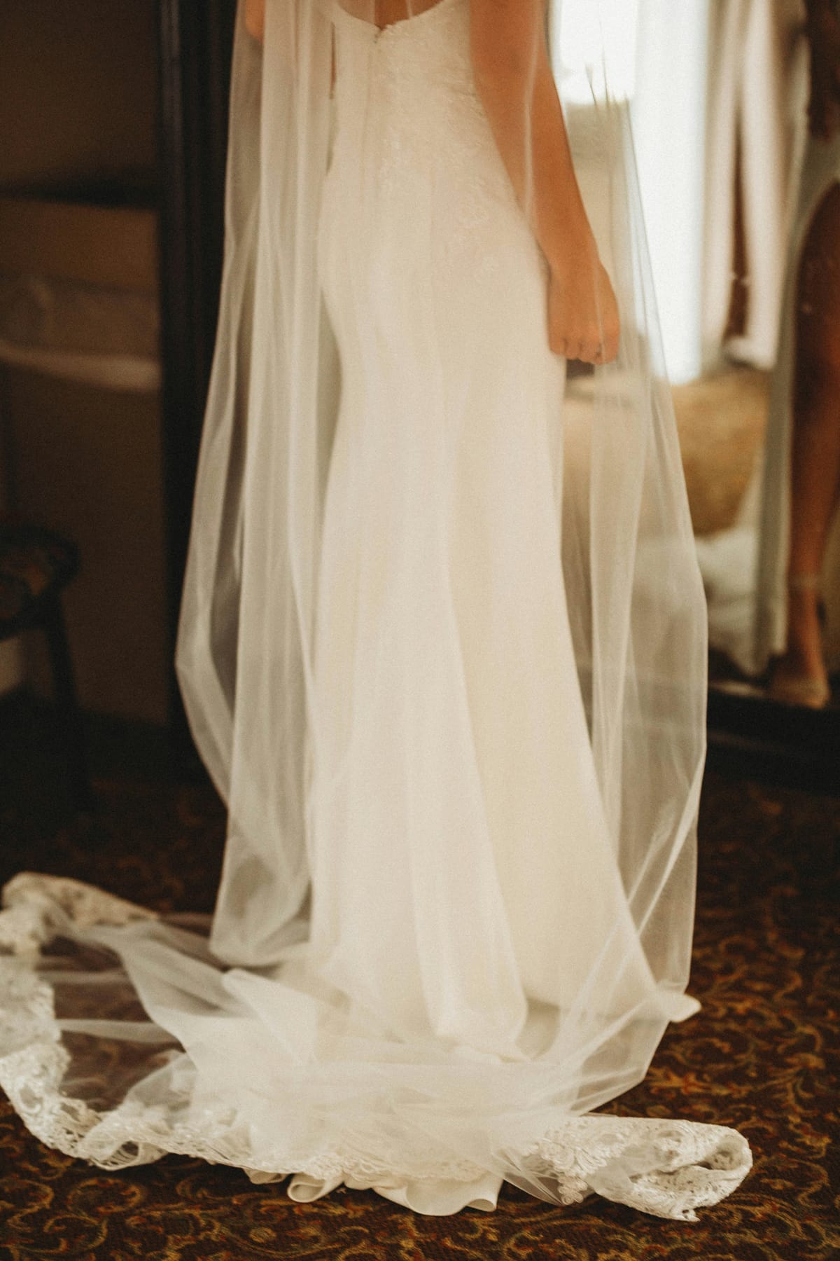 A bridal gown and veil catching the window light
