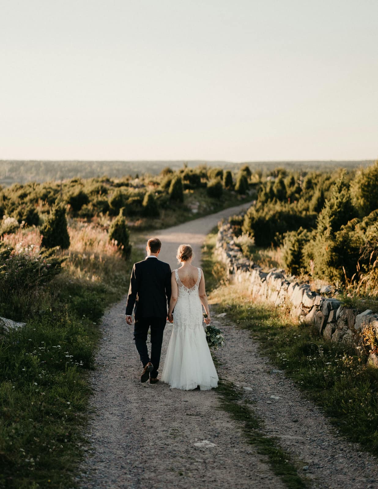 A couple walking a country path between the trees