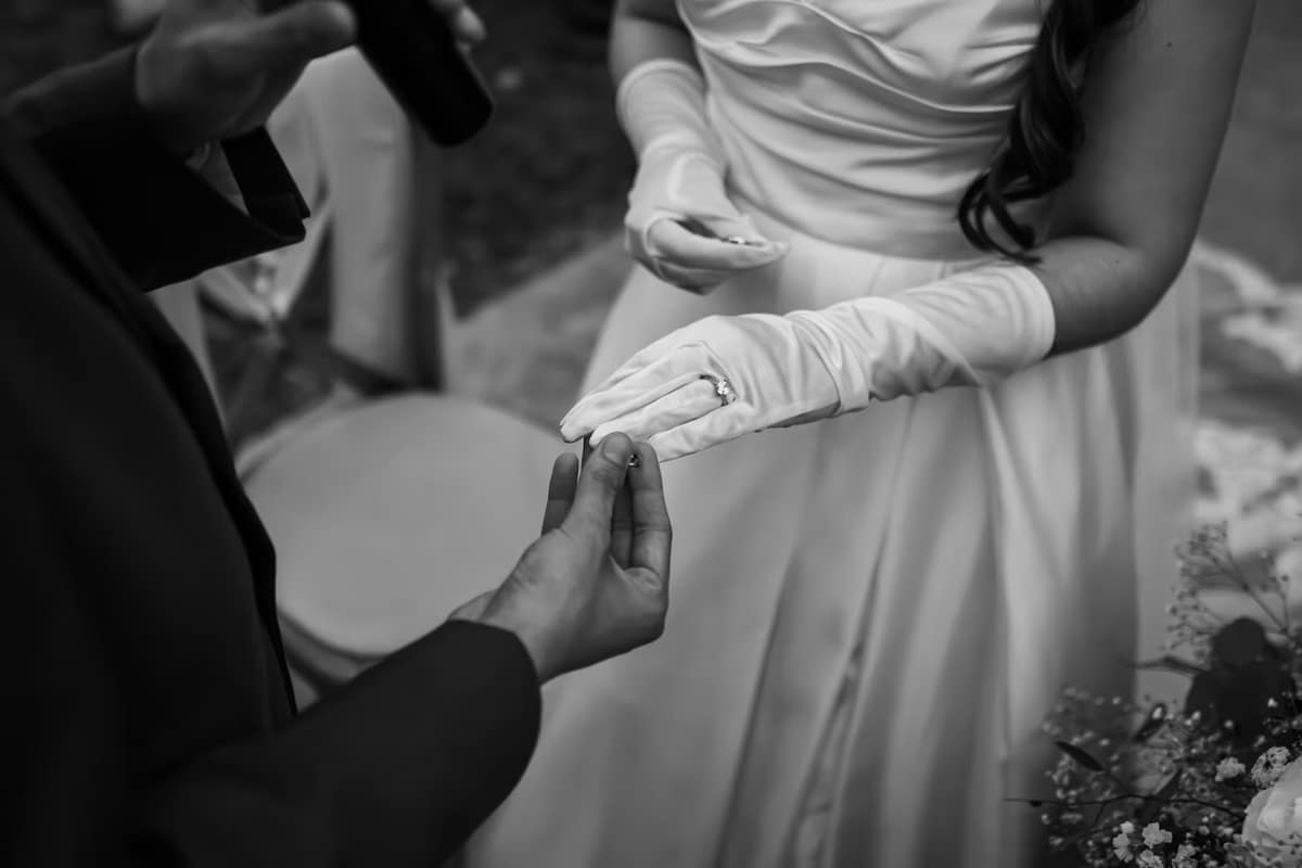 A gloved hand receiving a note on the wedding day