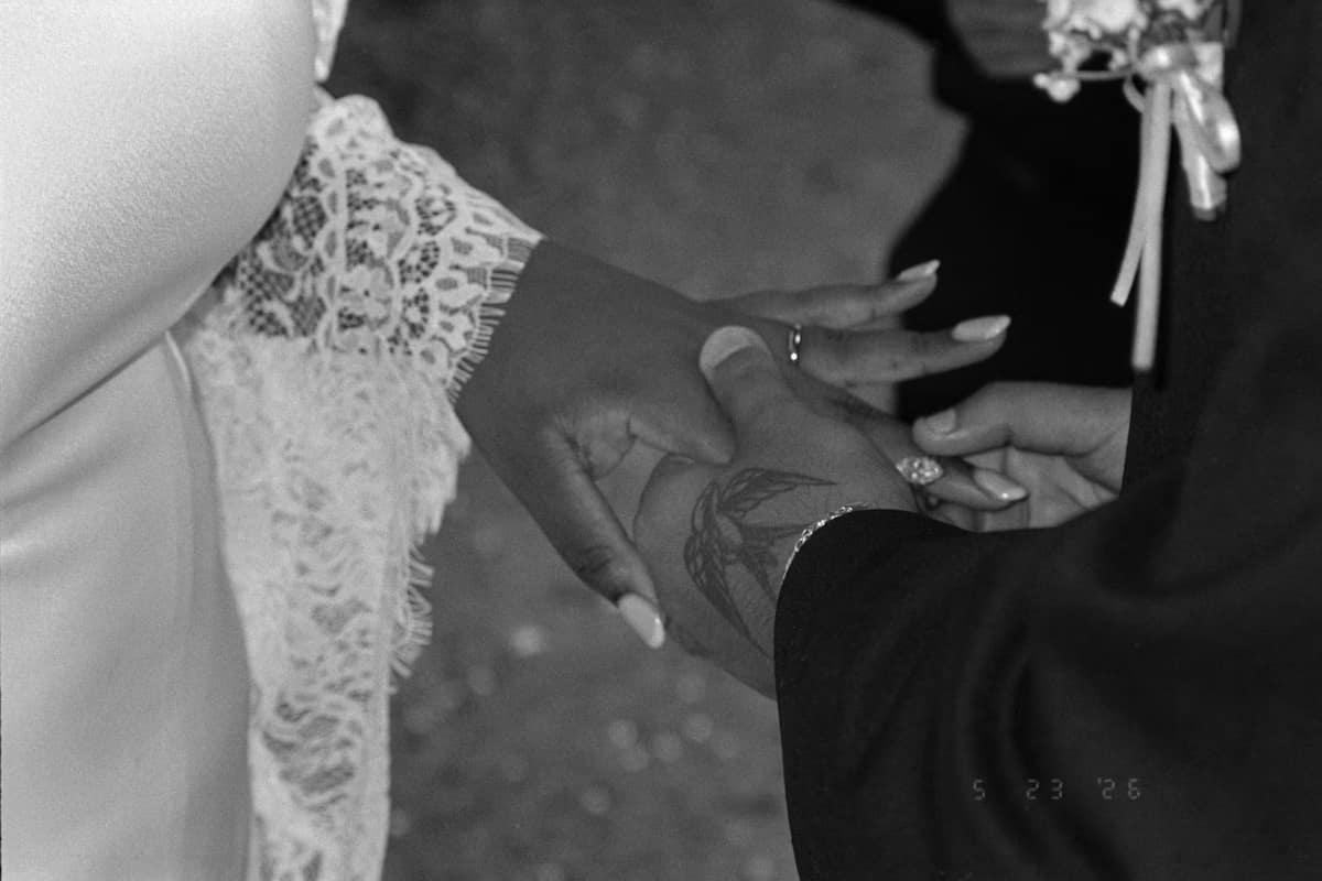 Hands joined in support on the wedding day, in black and white
